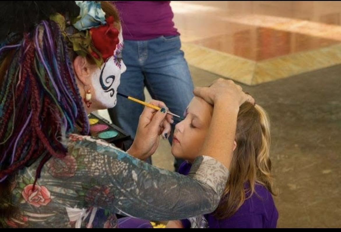 Brigid painting a child's face at an event